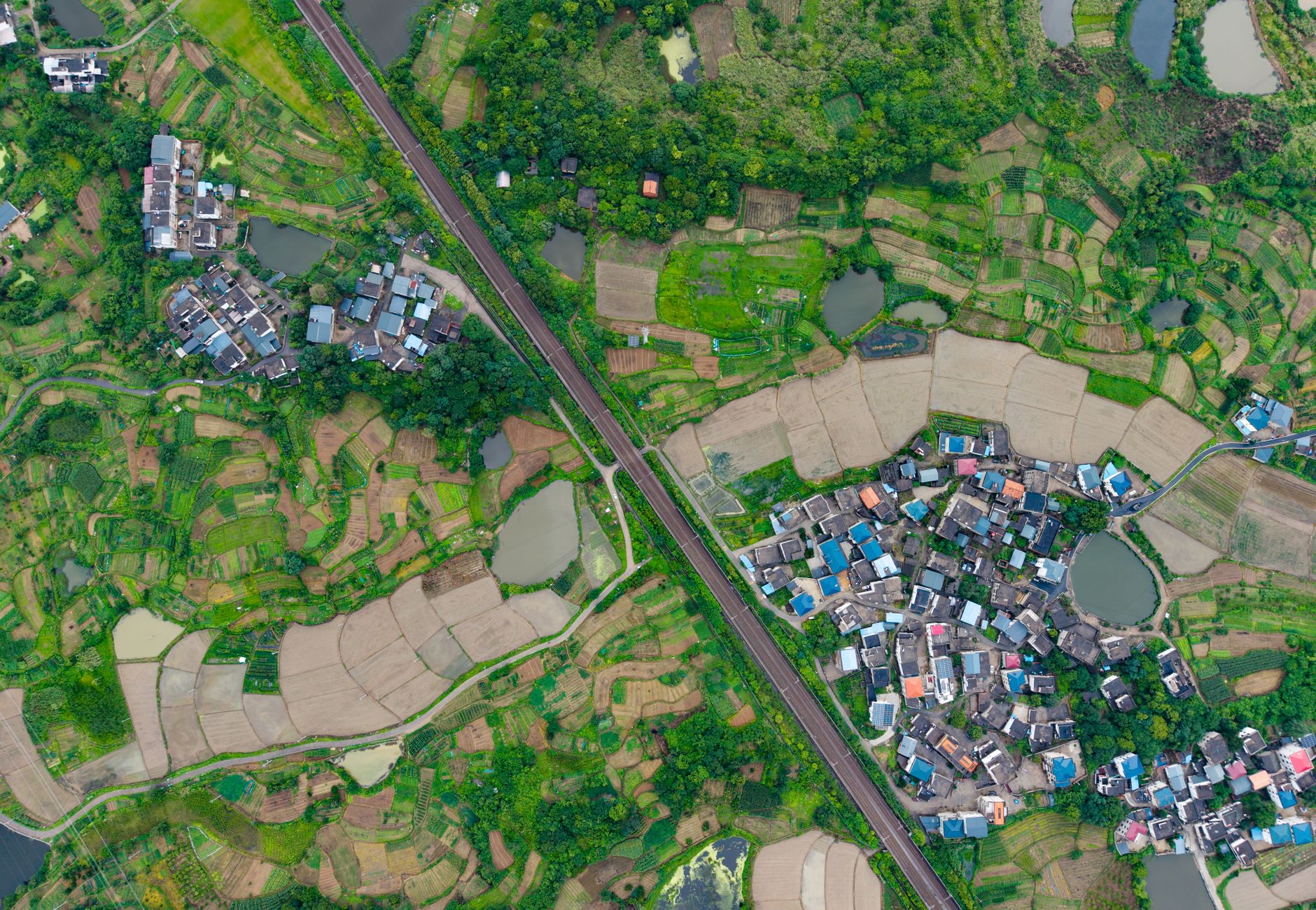 A stunning aerial shot showcasing vibrant green rice terraces and small villages in China.