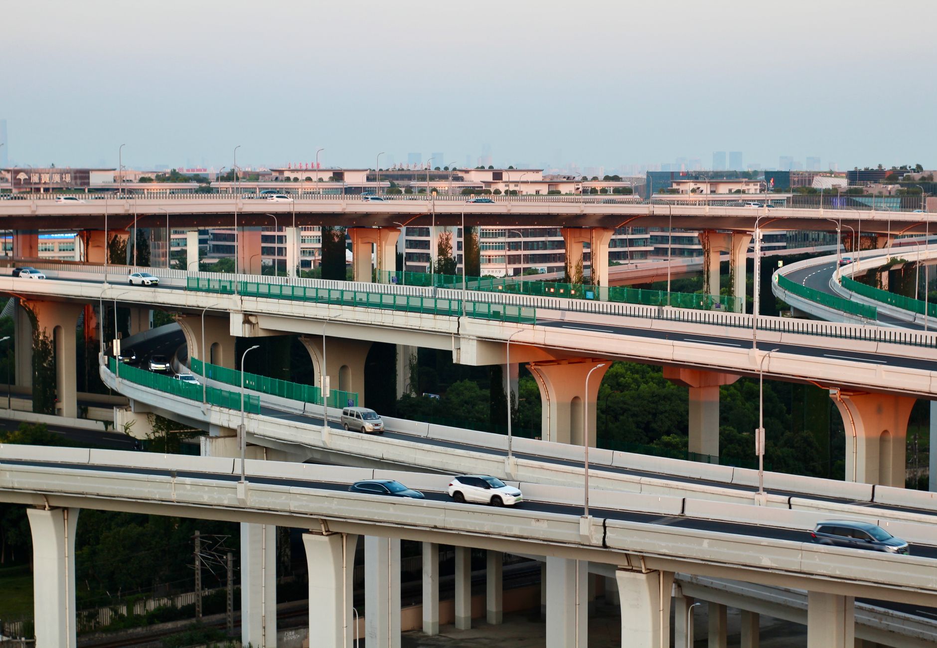 Aerial view of a modern highway interchange at dusk with flowing traffic.