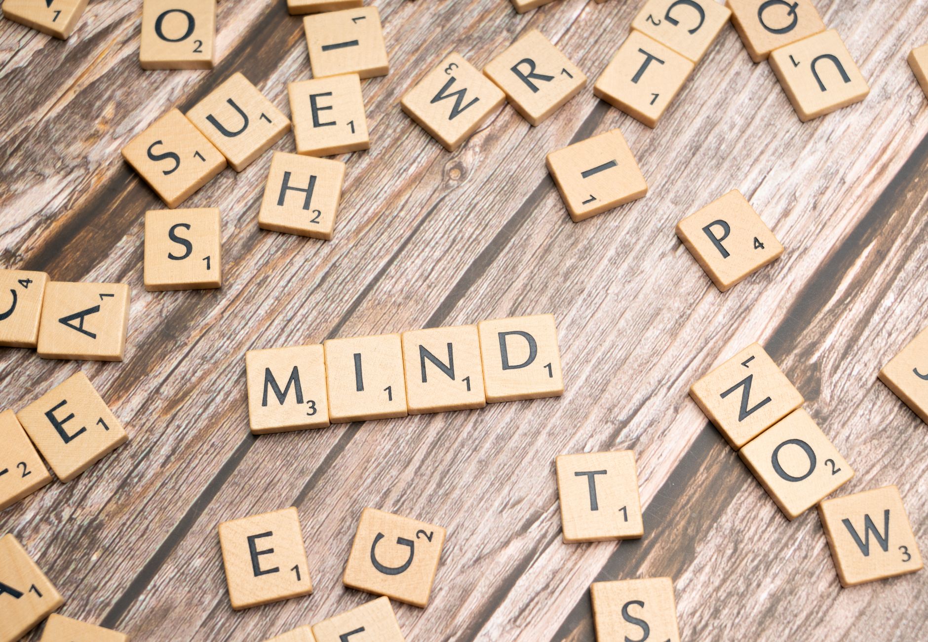 Scattered wooden letter tiles on a rustic wood surface highlighting the word 'Mind'. Ideal for mental and cognitive themes.